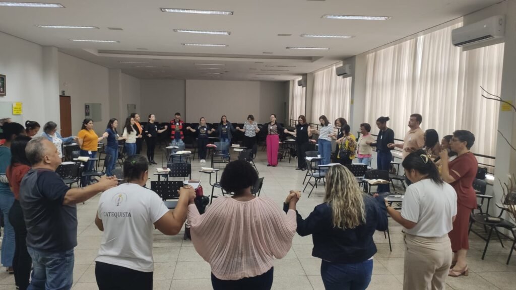 Catequistas da Diocese de Uberlândia rezam de mãos dadas emo em encontro de formação na PUC-SP